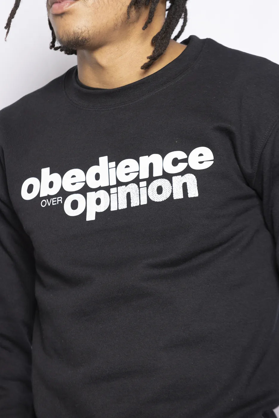 Close-up of the black Obedience Over Opinion crewneck.